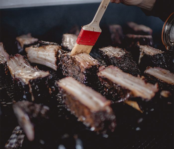 Pulled pork, ribs ou beef ribs : quelle pièce choisir pour votre événement ? Temps de cuisson, texture, format idéal — le guide complet du fumoir texan avec Marché Noir