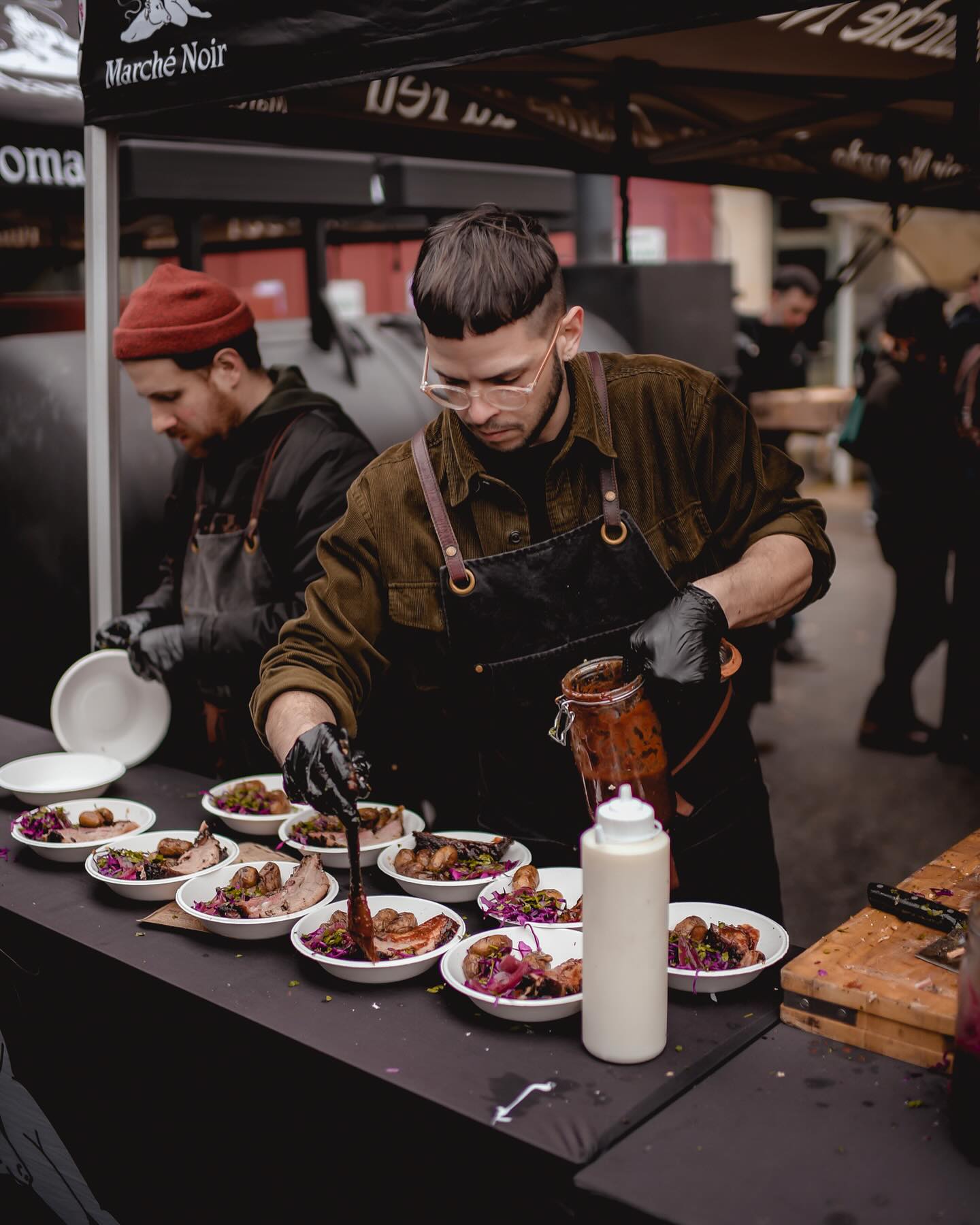 Chef Marché Noir dressant les assiettes en direct pendant un événement
